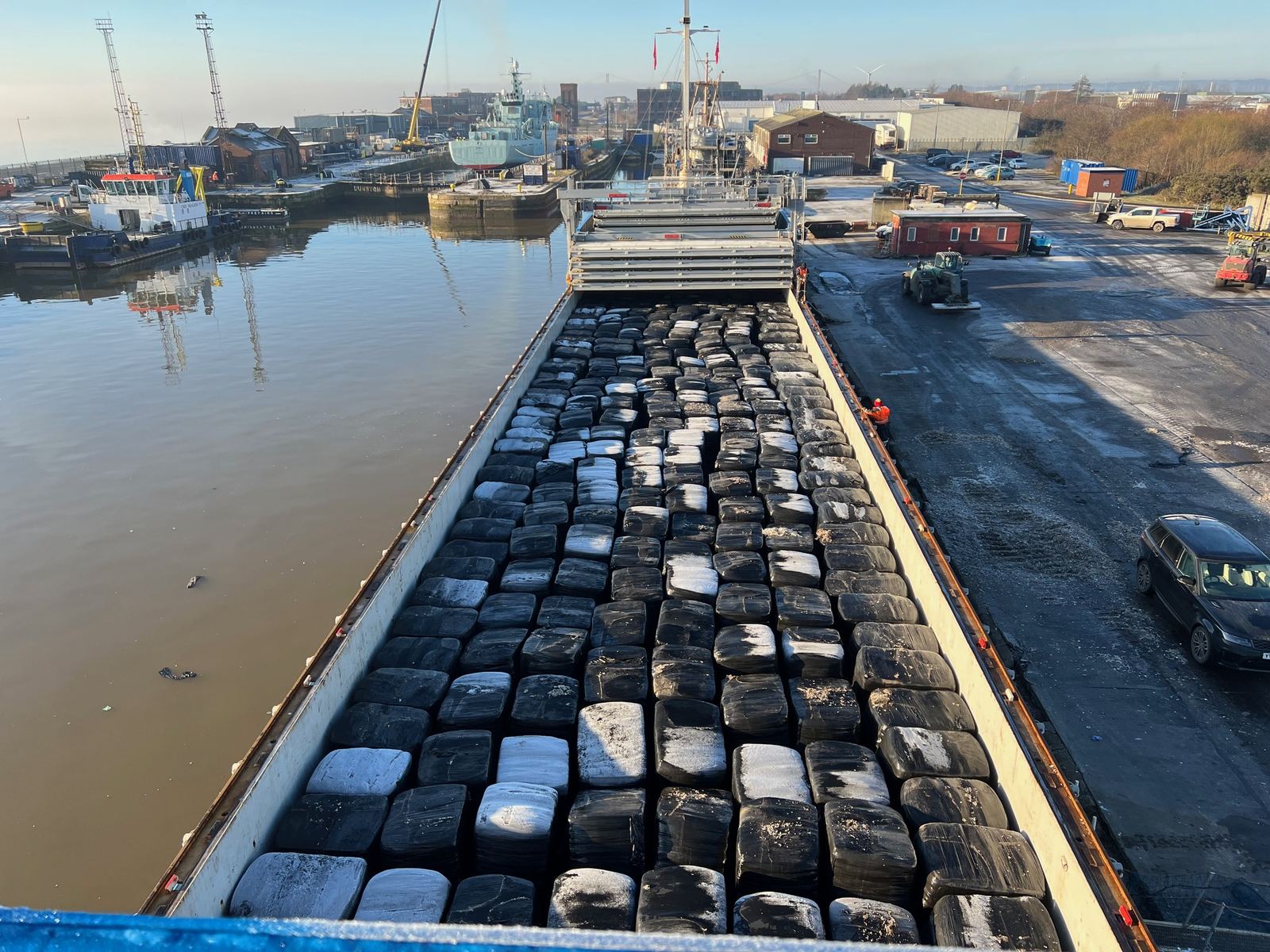 Ship's hold full of wrapped fuel bales at the dock