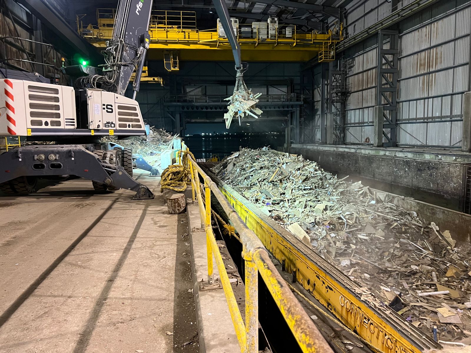 Material handler loading waste in a processing hall